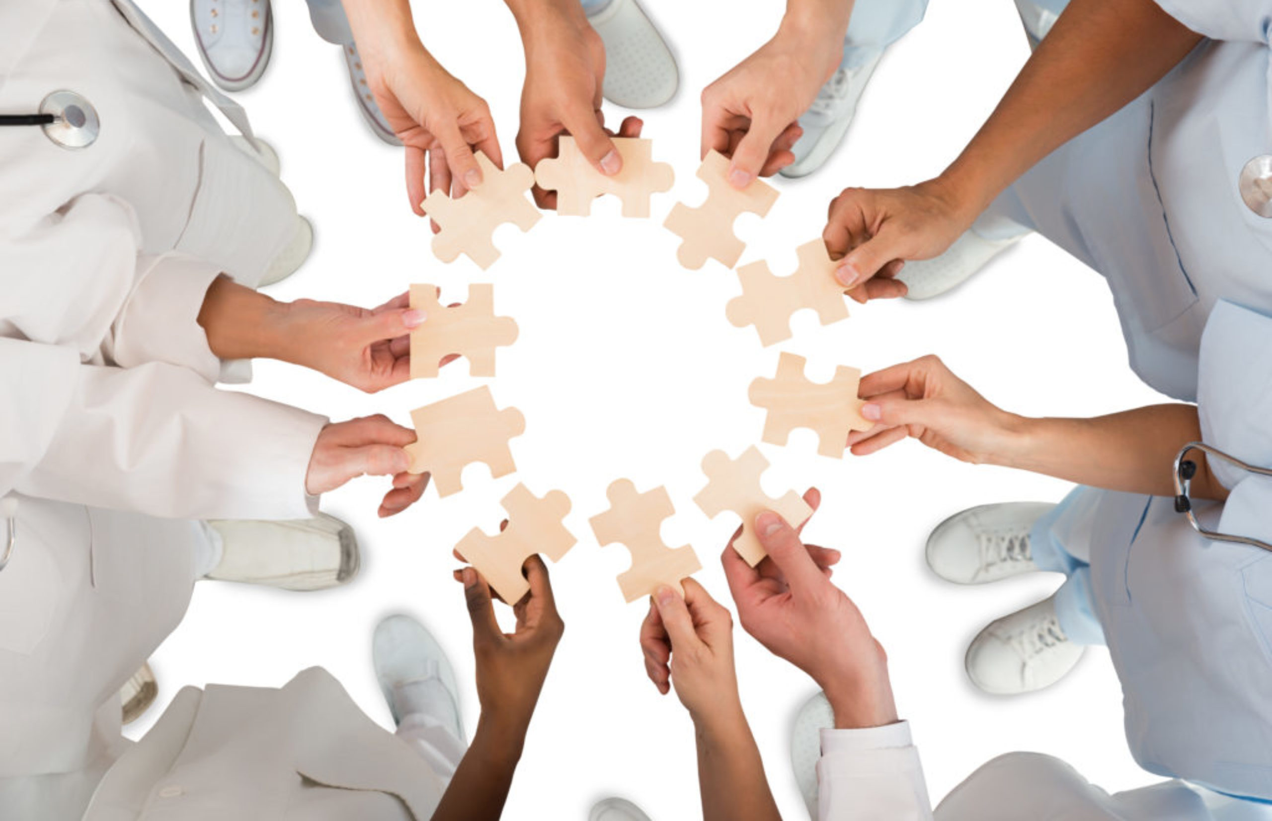 Medical Team Holding Jigsaw Pieces In Huddle