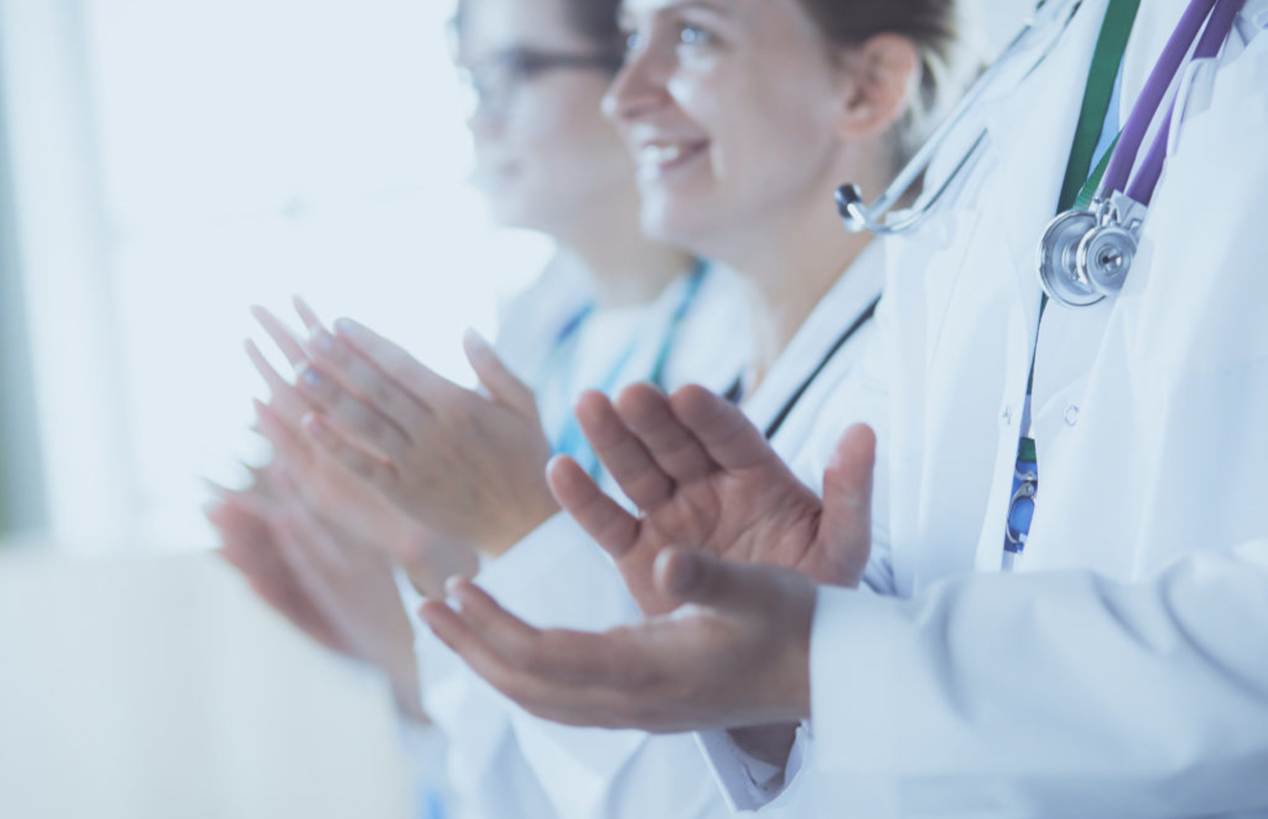 Medical team clapping their hands during a meeting